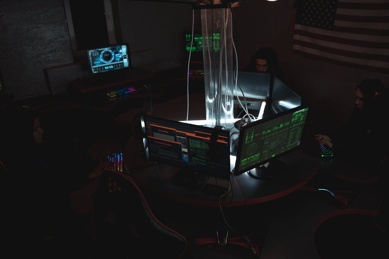 Team of cybersecurity experts collaboratively working on data protection in a dimly lit room filled with computers.